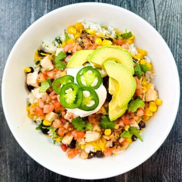 white bowl with Mexican rice bowl and lots of toppings