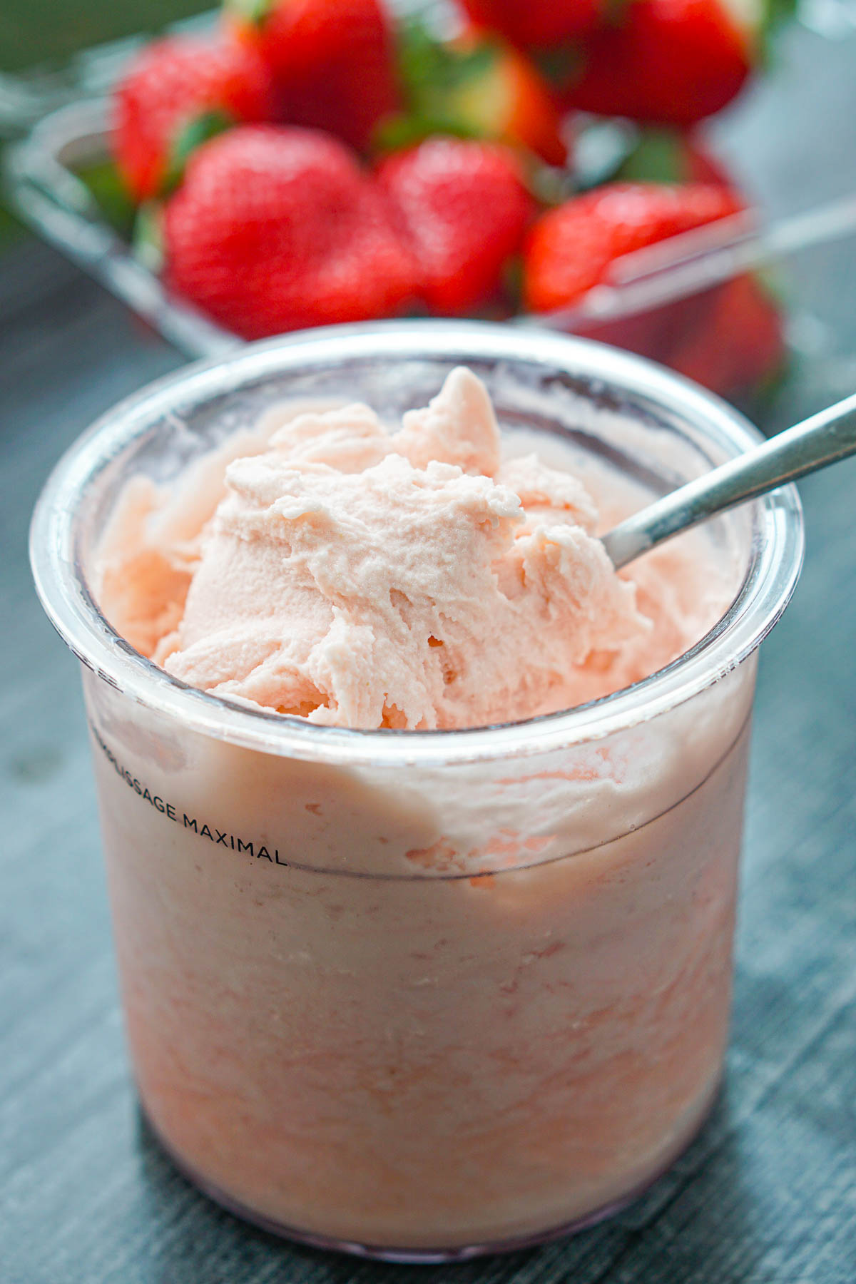 closeup of a pint container with creamy healthy strawberry ice cream