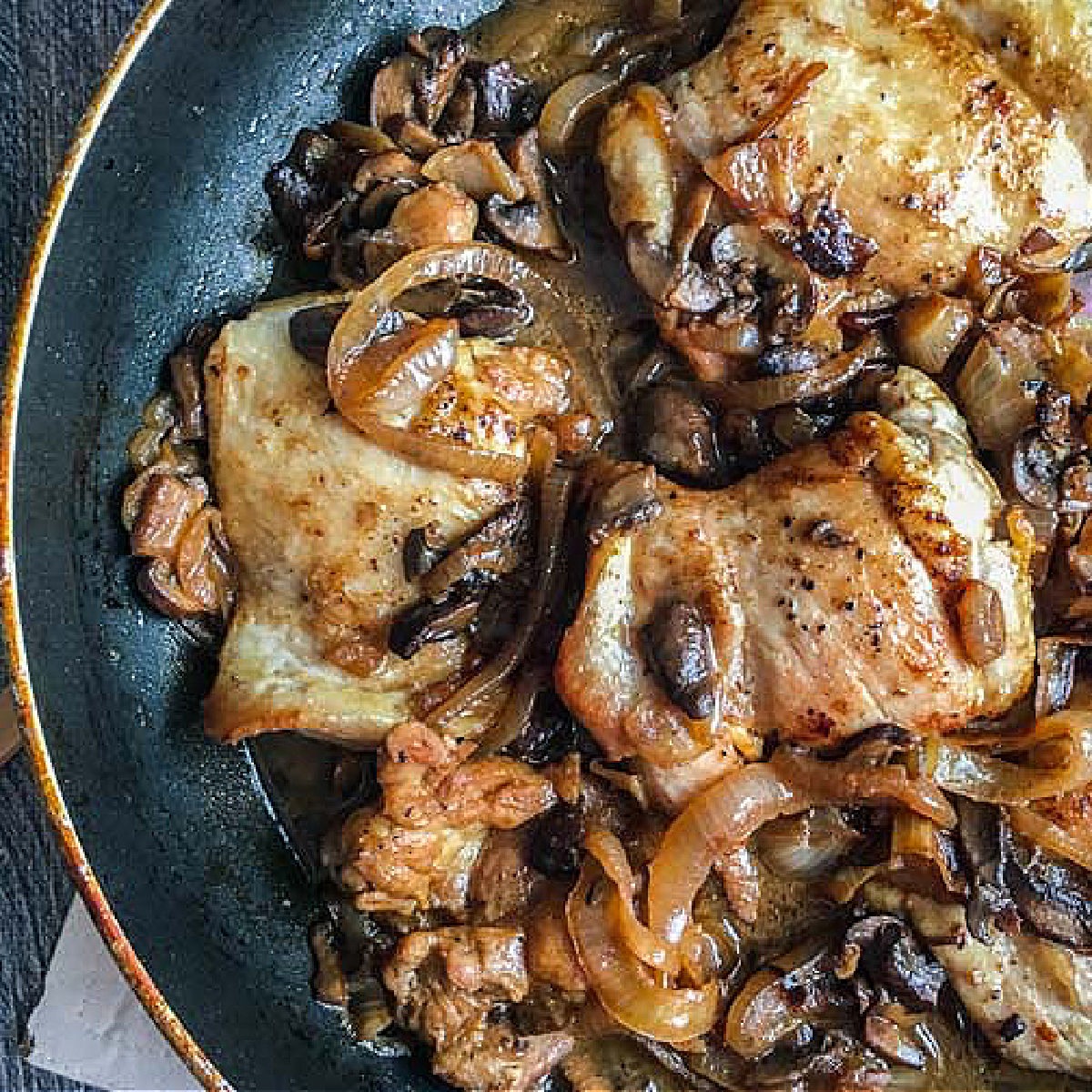 skillet with chicken thighs and balsamic onions and mushrooms