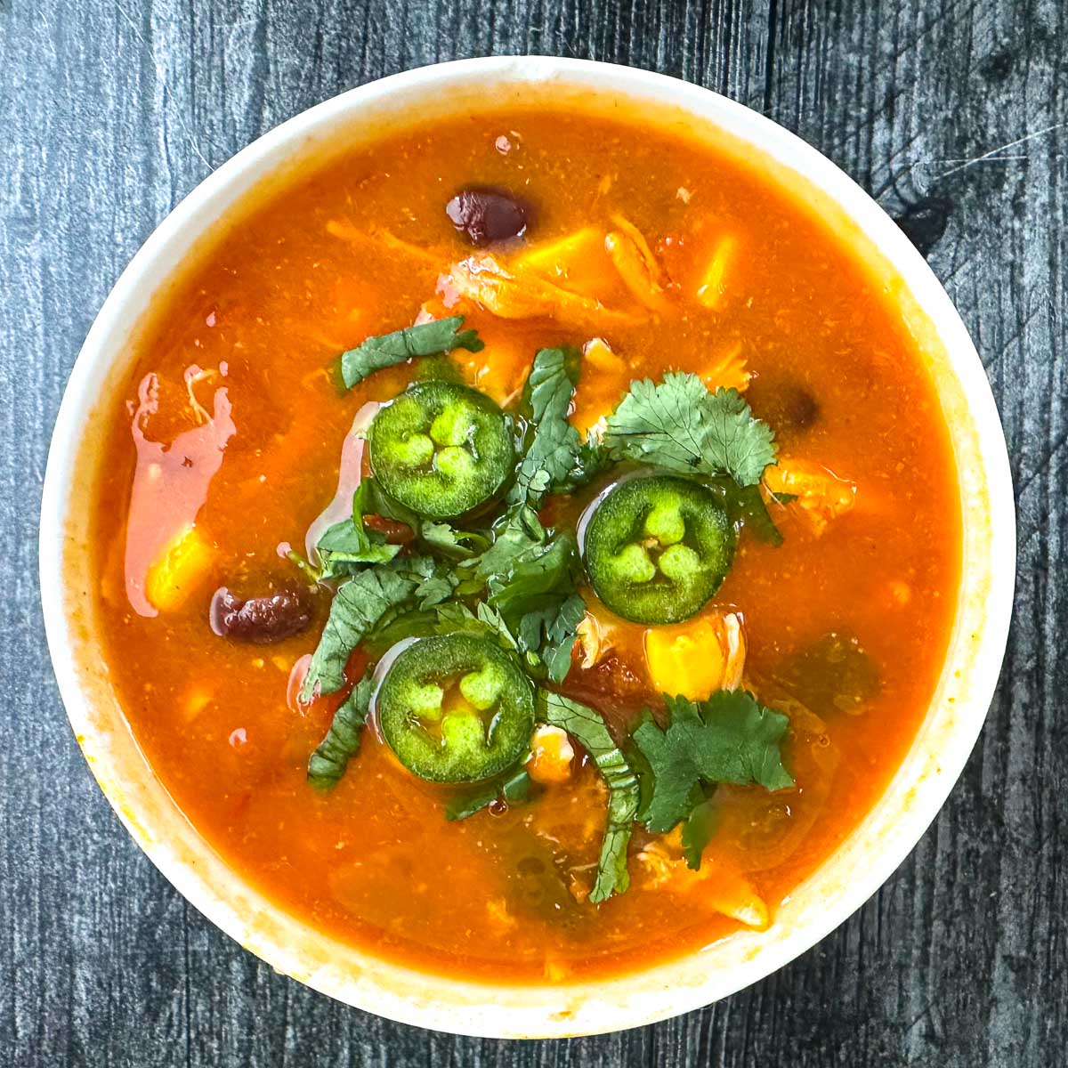 white bowl with easy chicken tortilla soup made in slow cooker