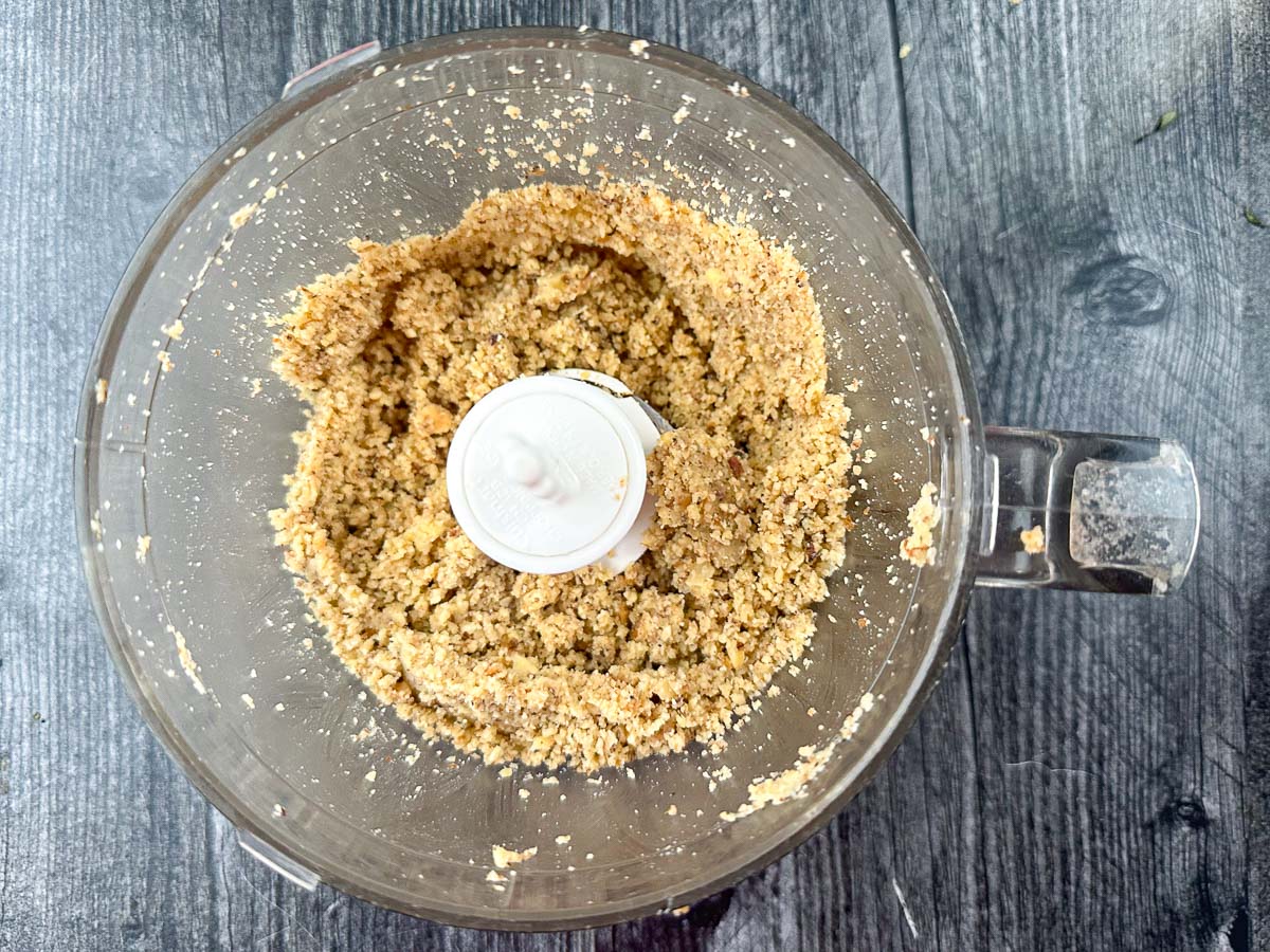 food processor bowl with crushed walnuts