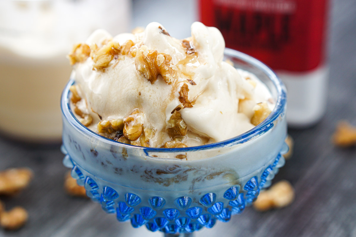 closeup of ie cream bowl with maple syrup and walnuts sundae