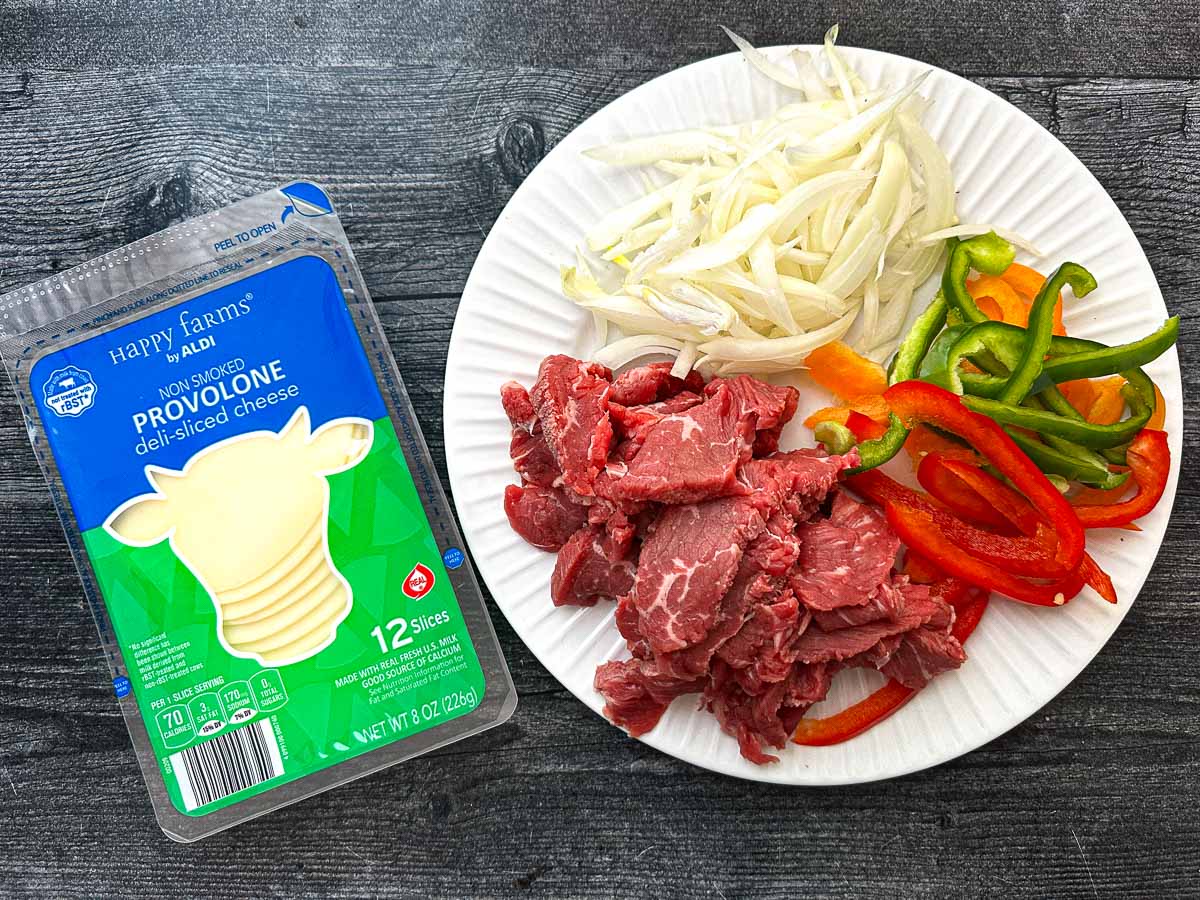 Recipe ingredients for stuffing portobello mushrooms - provolone cheese, chopped onions and peppers and beef slices.