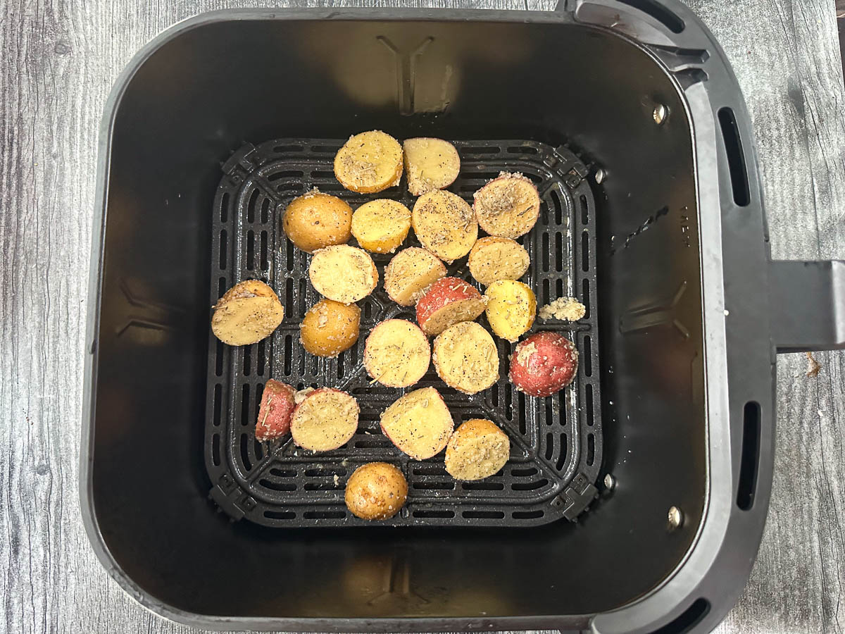 air fryer basket with semi roasted potatoes