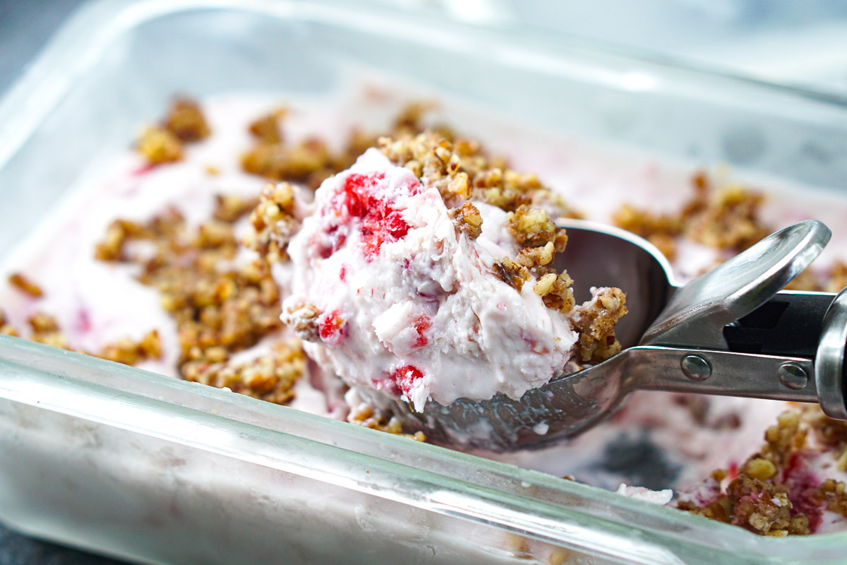 scoop of frozen raspberry protein ice cream with nuts on top