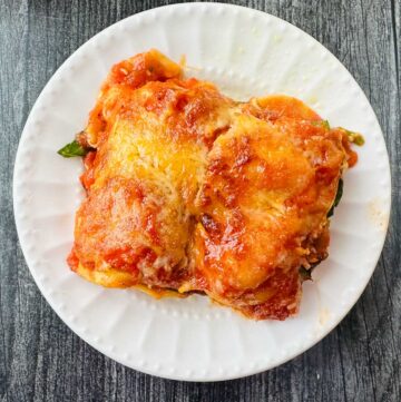 white plate with a piece of air fryer lasagna made with ravioli