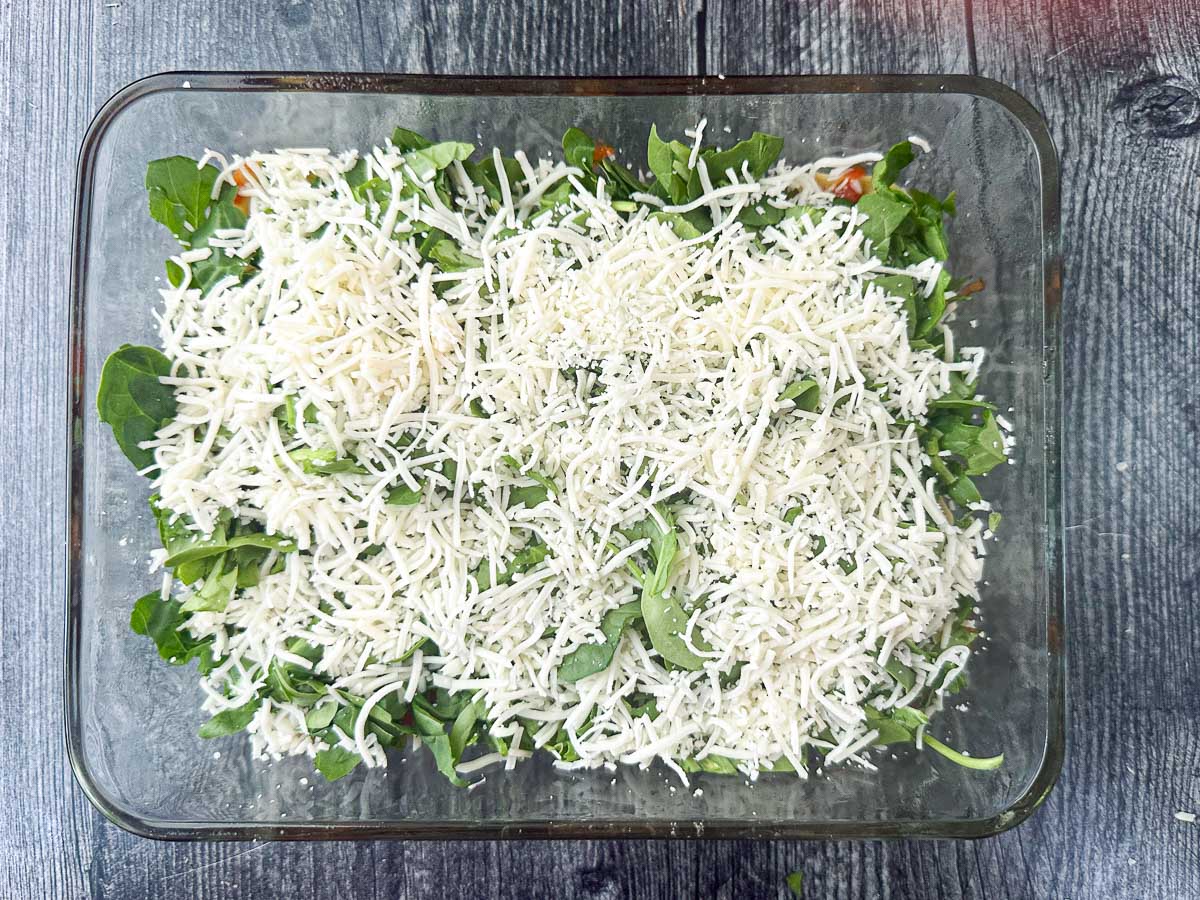 baking dish with a layer of spinach and cheese