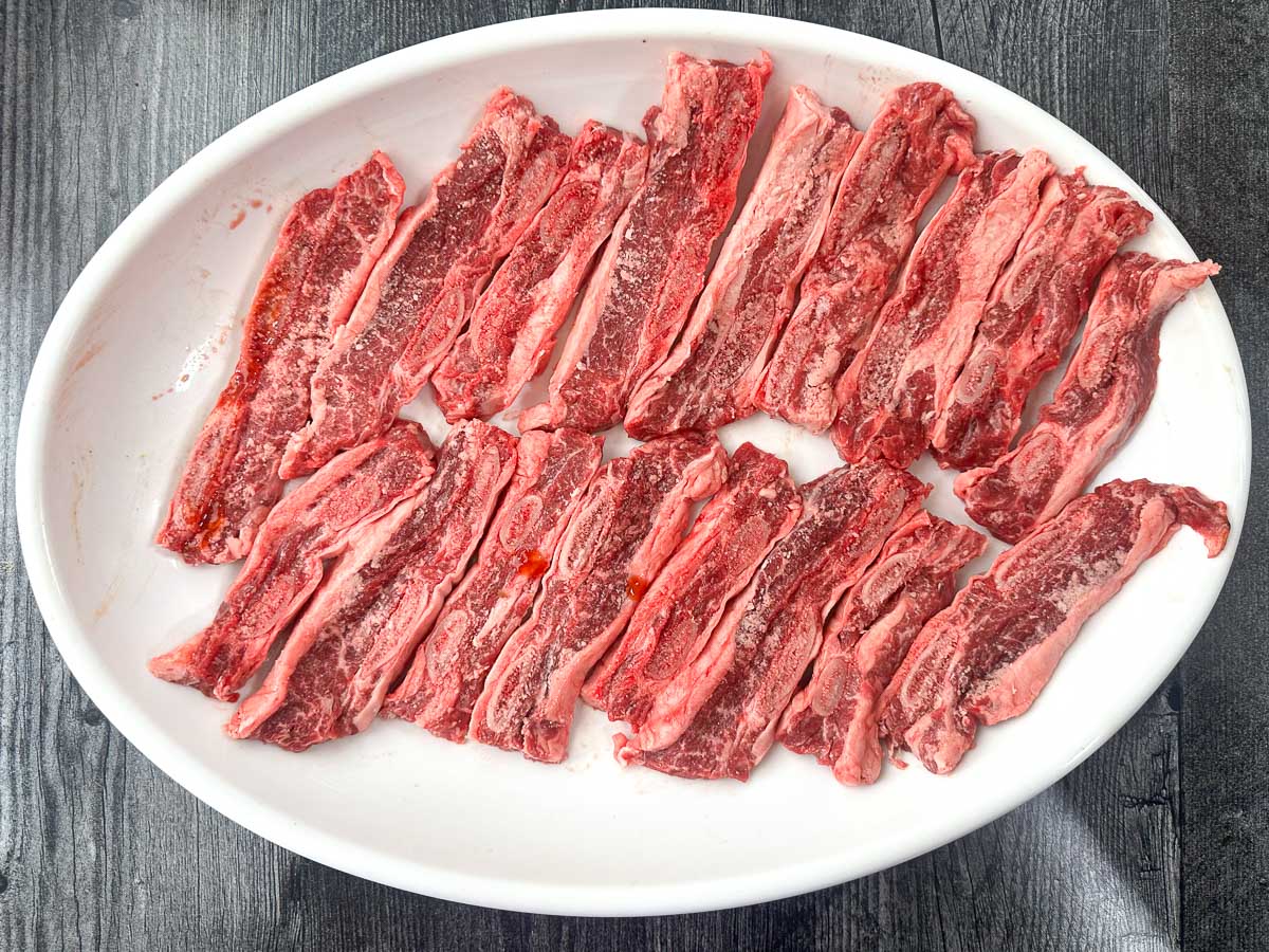 white platter with raw flanken ribs cut in half