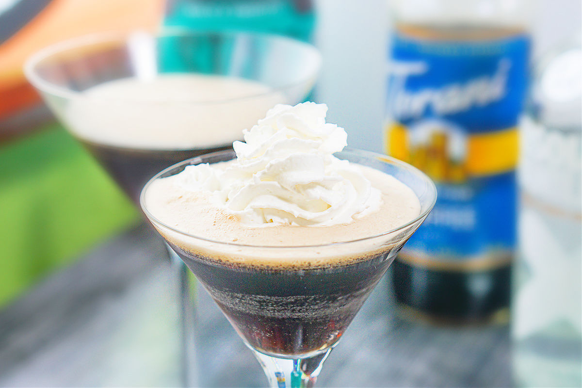 closeup of martini glass with coffee drink topped with whipped cream