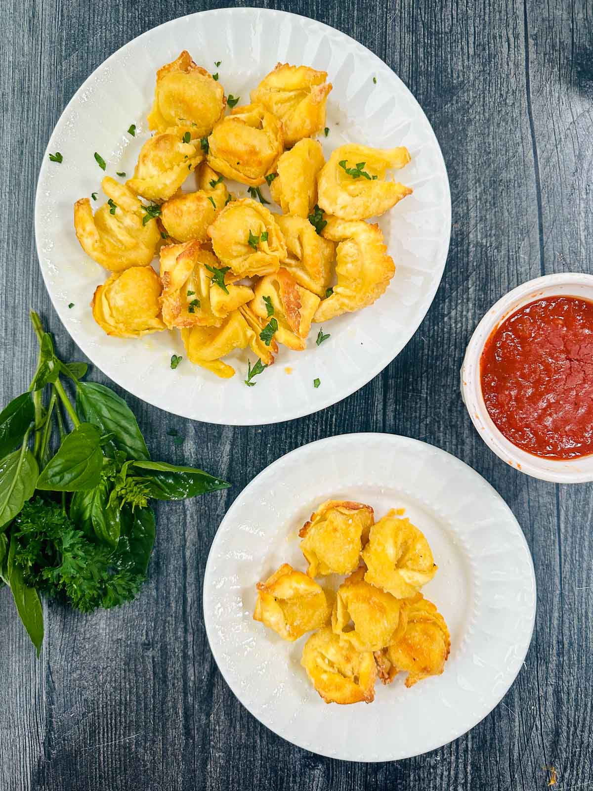 aerial view of white plates with air fried tortellini and fresh basil