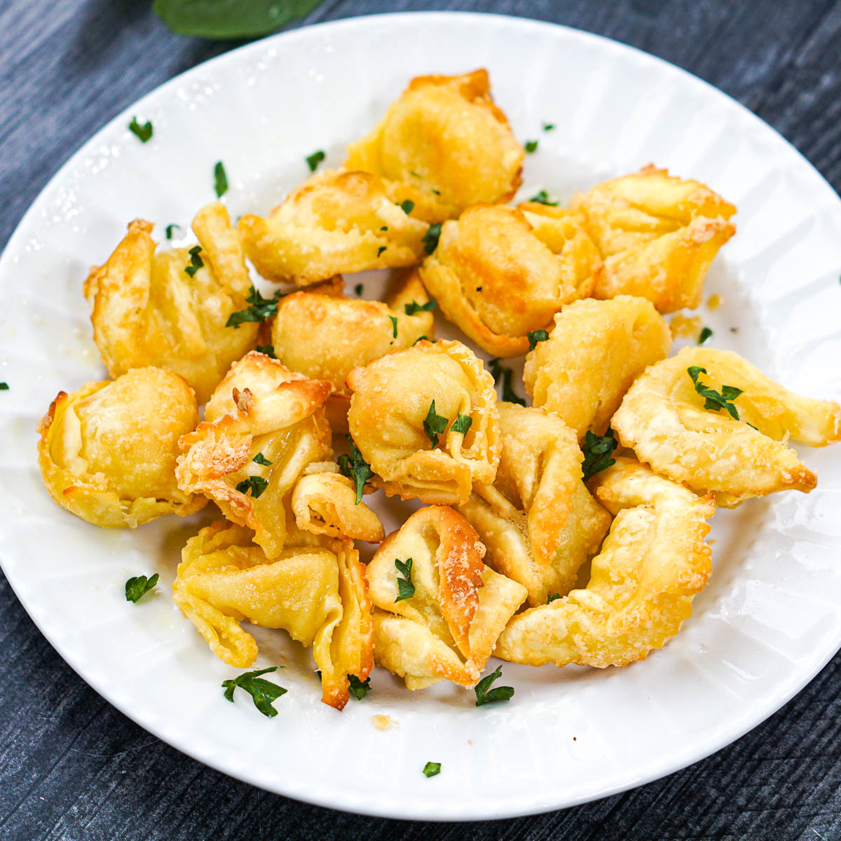 closeup of airfryer tortellini with fresh basil over top