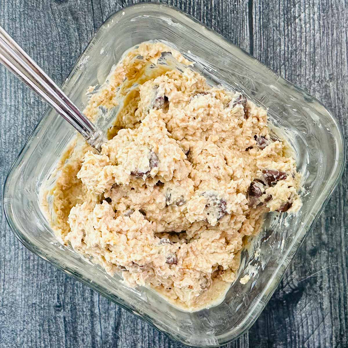 glass container with cookie dough oatmeal and a spoon