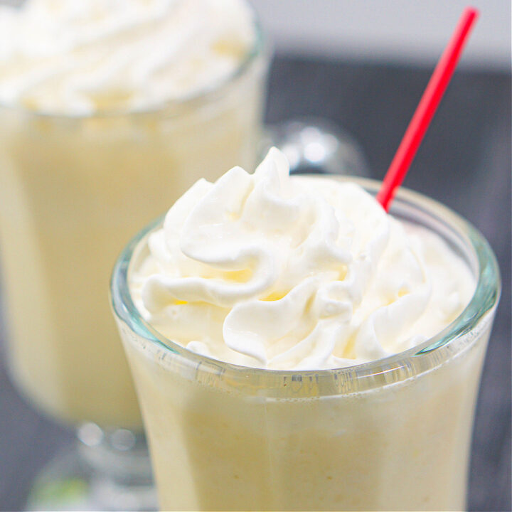 peanut butter whiskey milkshake with whipped cream and a red straw