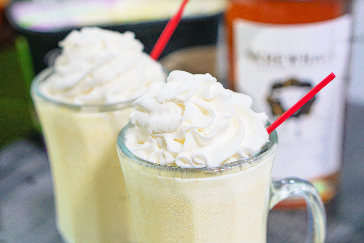  closeup of 2 skrewball peanut butter whiskey milkshakes with ingredient in background