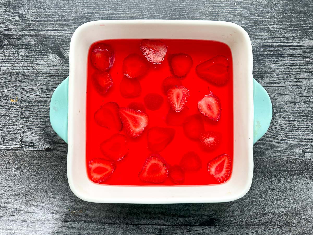 baking dish with strawberry jello with strawberries in it.