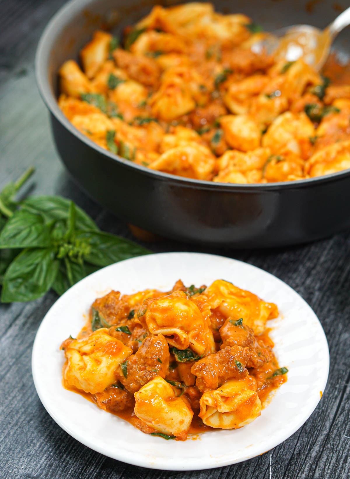 white plate with tortellini with vodka sauce and sausage