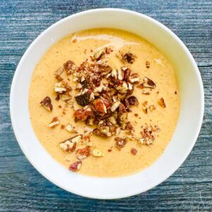 white bowl with pumpkin whipped cottage cheese with chopped nuts