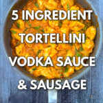 closeup of a pan of creamy vodka sauce on tortellini and sausage with text