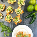 aerial view of white plate and muffin tin with crab wonton cups and limes and jalapeños and text
