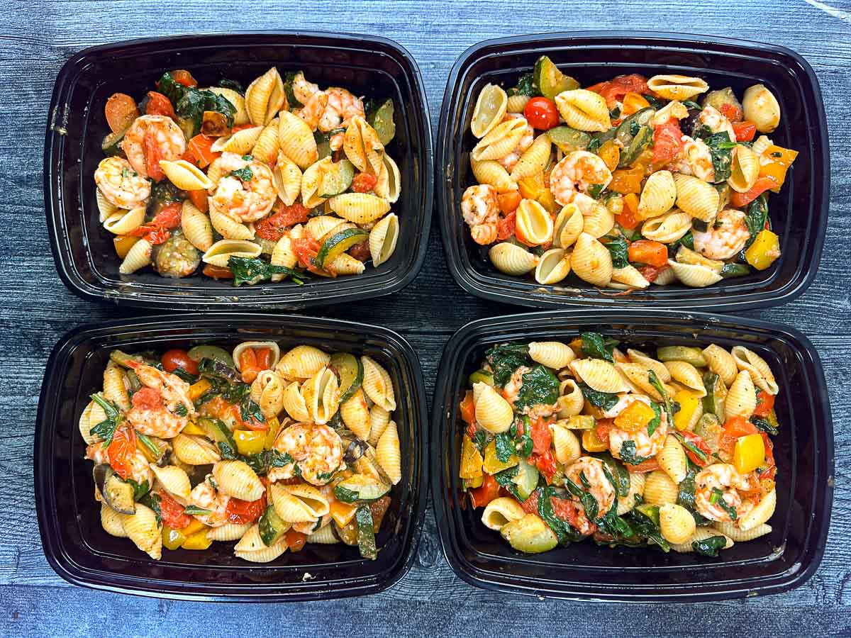 four black freezer containers with low calorie shrimp pasta