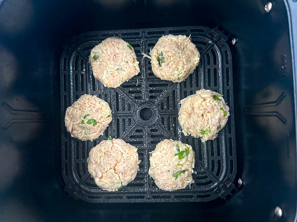 air fryer basket with raw chicken patties