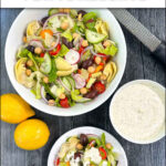 aerial view of a bowl and plate with Greek salad and a bowl of creamy dressing and fresh lemons and text