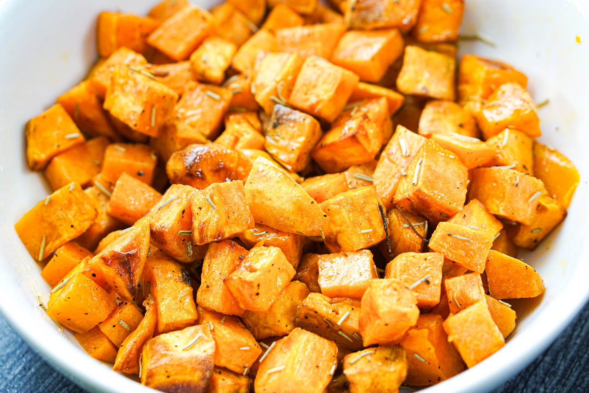 closeup of a white bowl with the roasted air fryer sweet potatoes