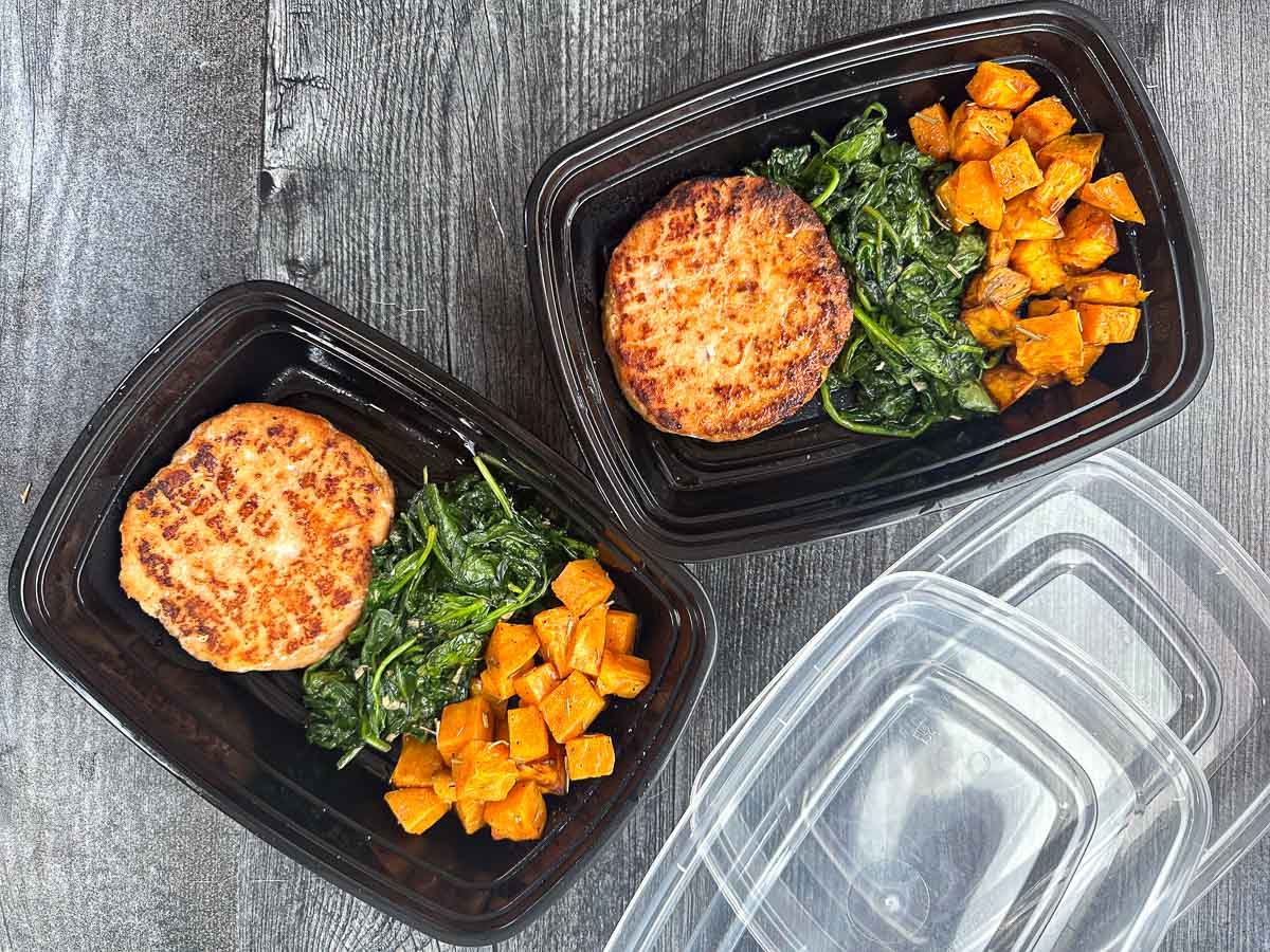 2 freezer containers with salmon burgers, spinach and sweet potatoes
