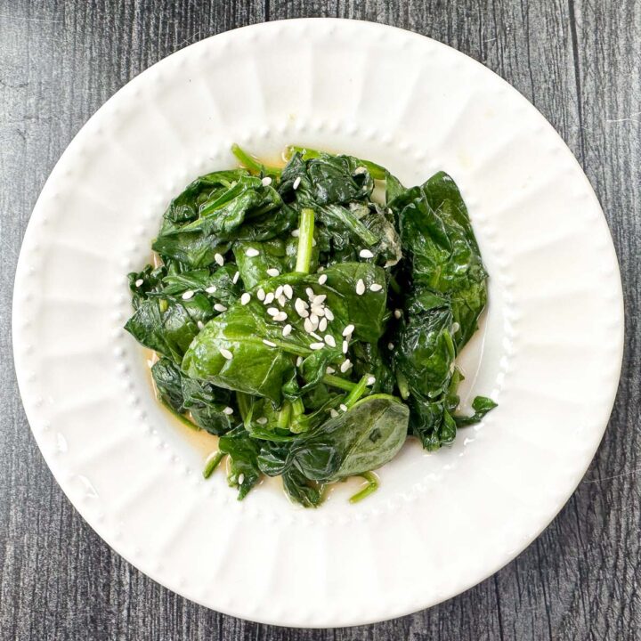 closeup of a white plate with Asian spinach stir fry
