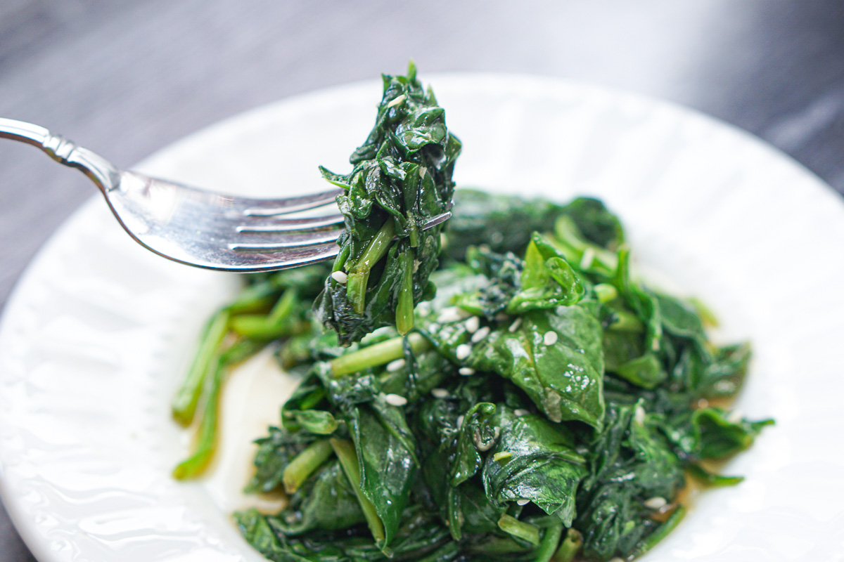 a forkful of asian spinach side dish