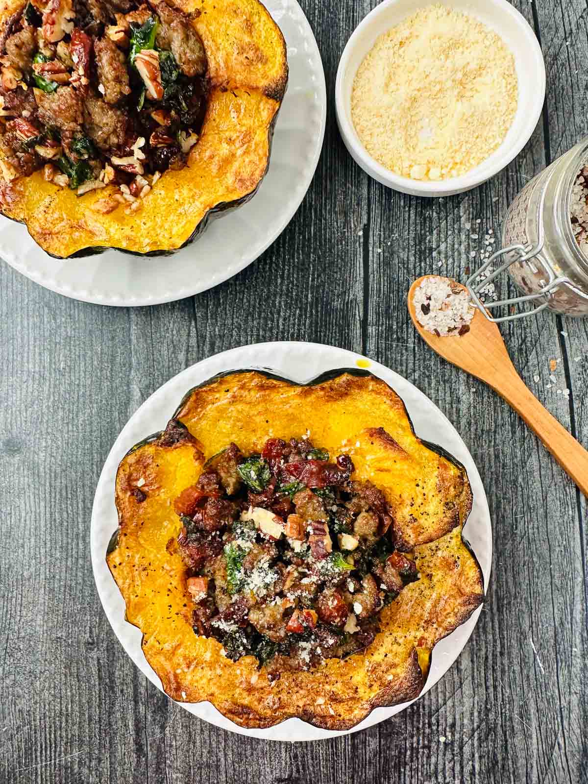 aerial view of white plate with air fryer acorn squash stuffed with sausage, sun dried tomatoes and spinach