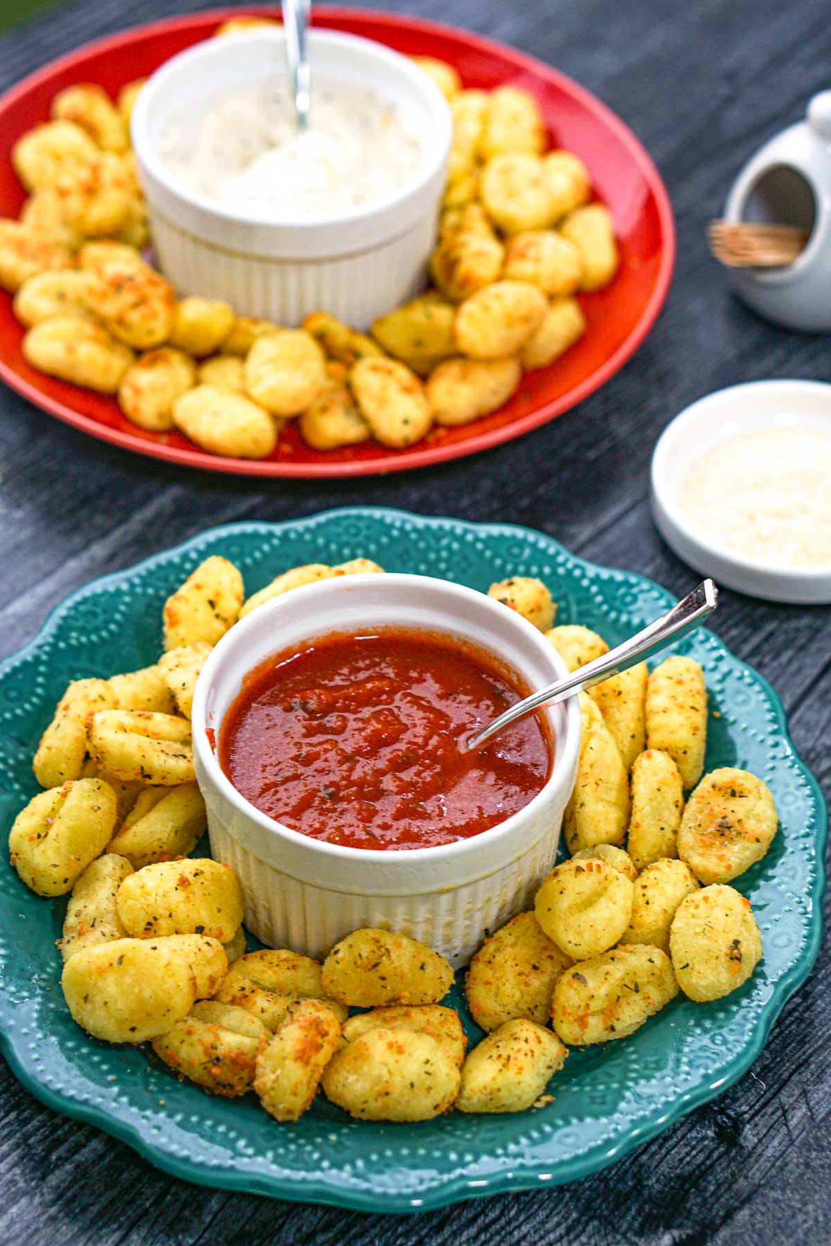 green and red plates with air fryer gnocchi and dips
