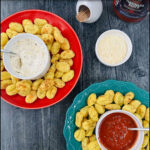 green and red plates with air fryer gnocchi and dips and text
