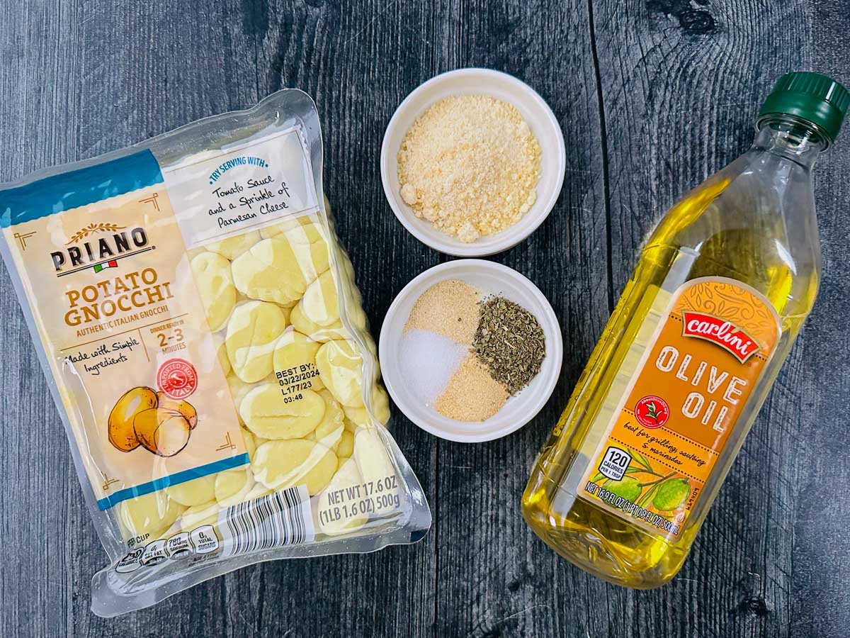 recipe ingredients - olive oil, spices, parmesan cheese and raw gnocchi