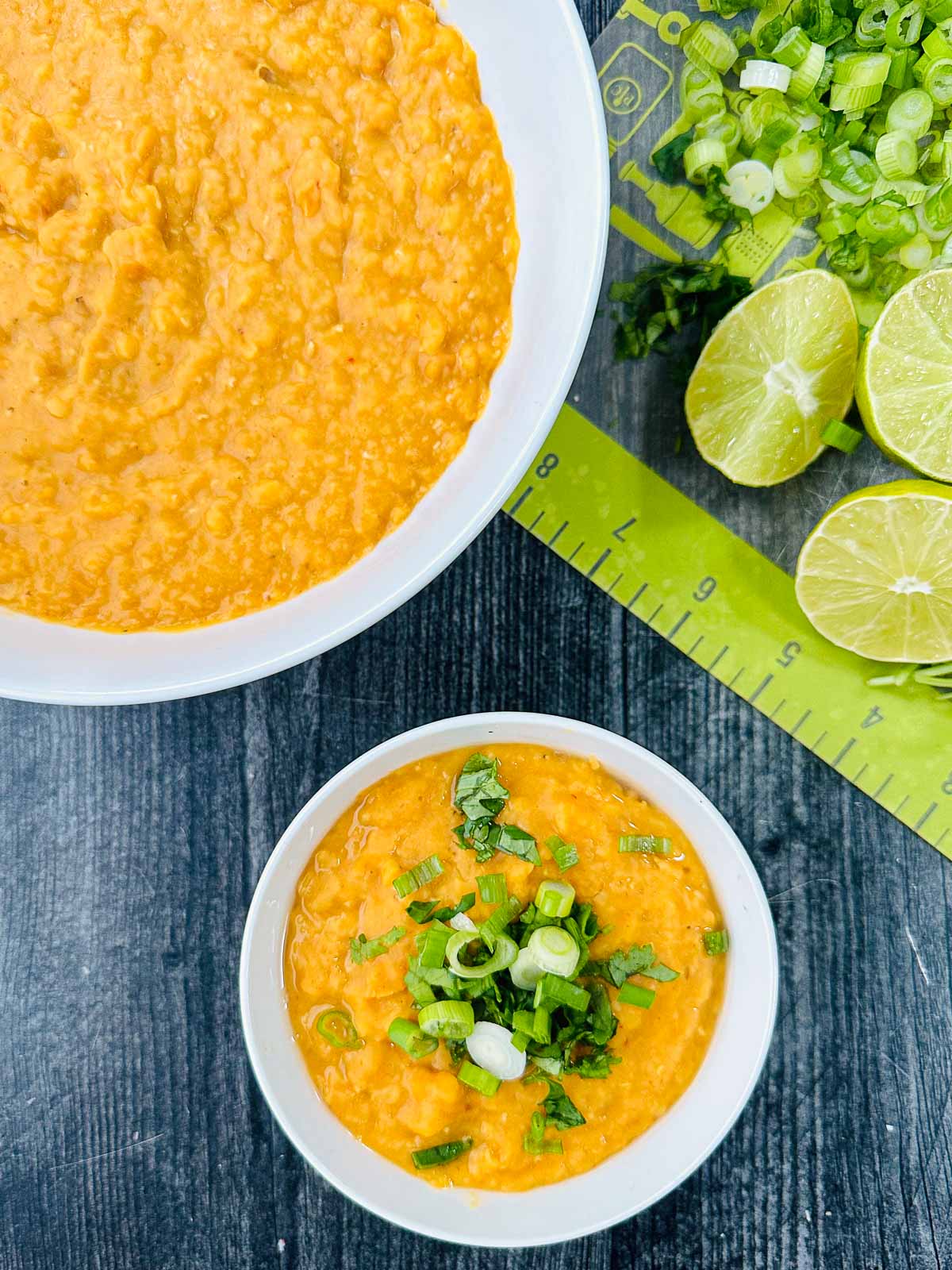 aerial view of bowls of Thai red curry lentils and fresh limes and cilantro