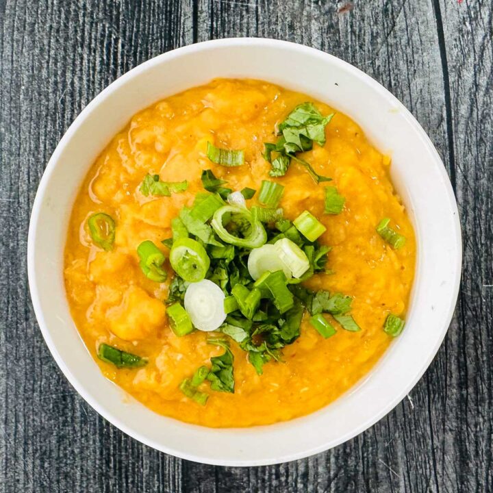 white bowl with Thai red curry lentils with green onions and cilantro