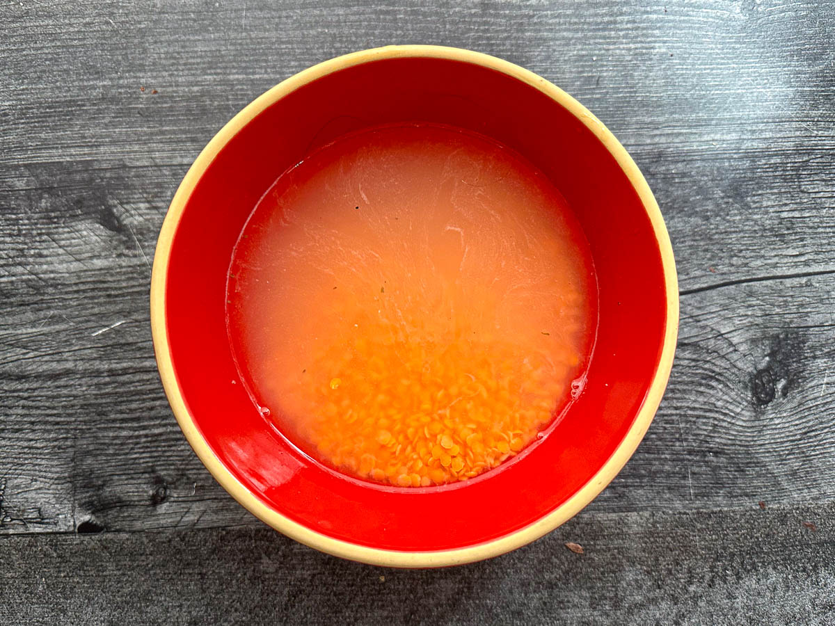 red bowl with lentils soaking