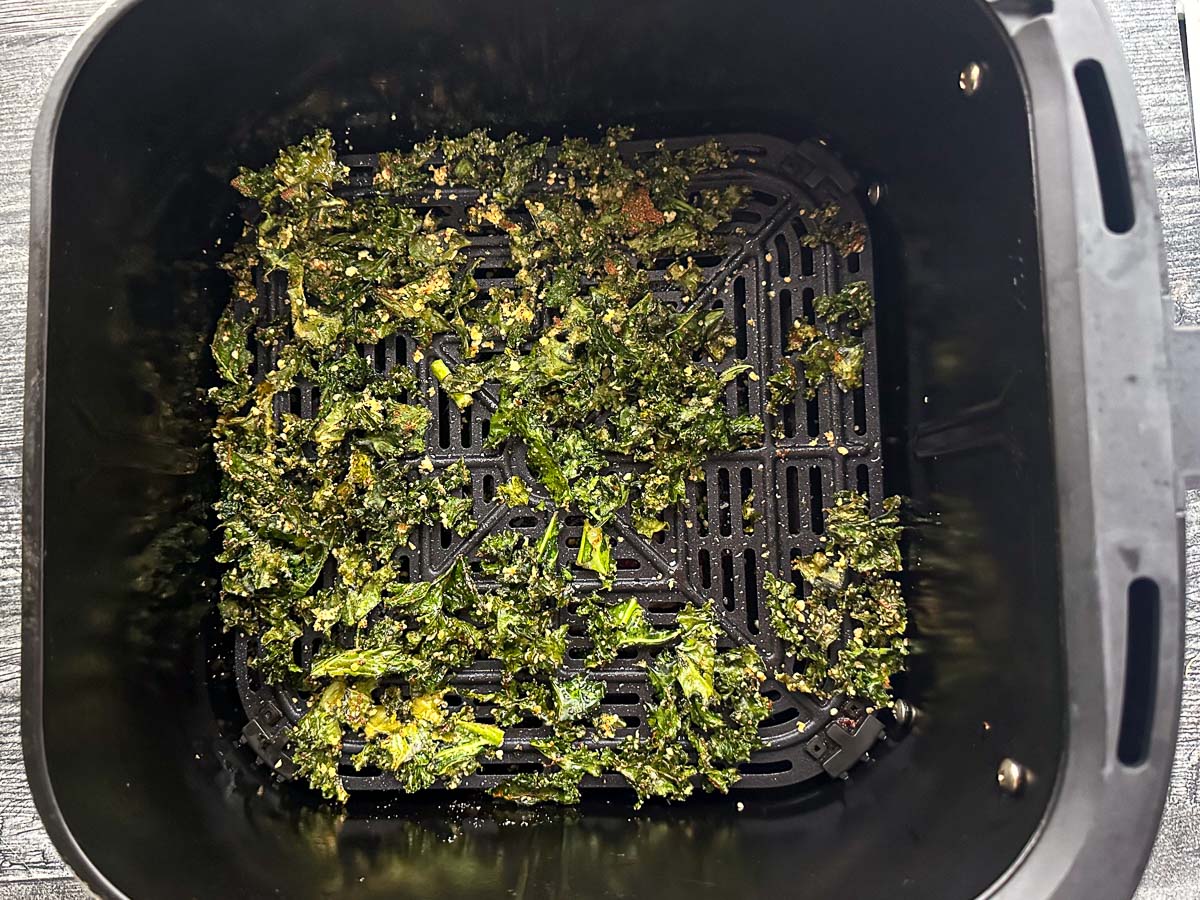 air fryer basket with finished kale chips
