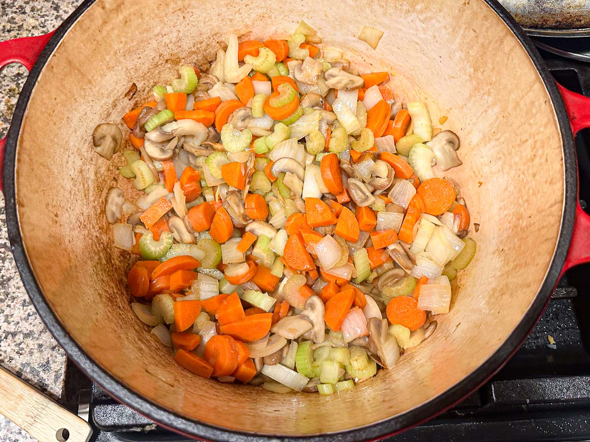 pot with sautéed carrots, onions, celery and mushrooms