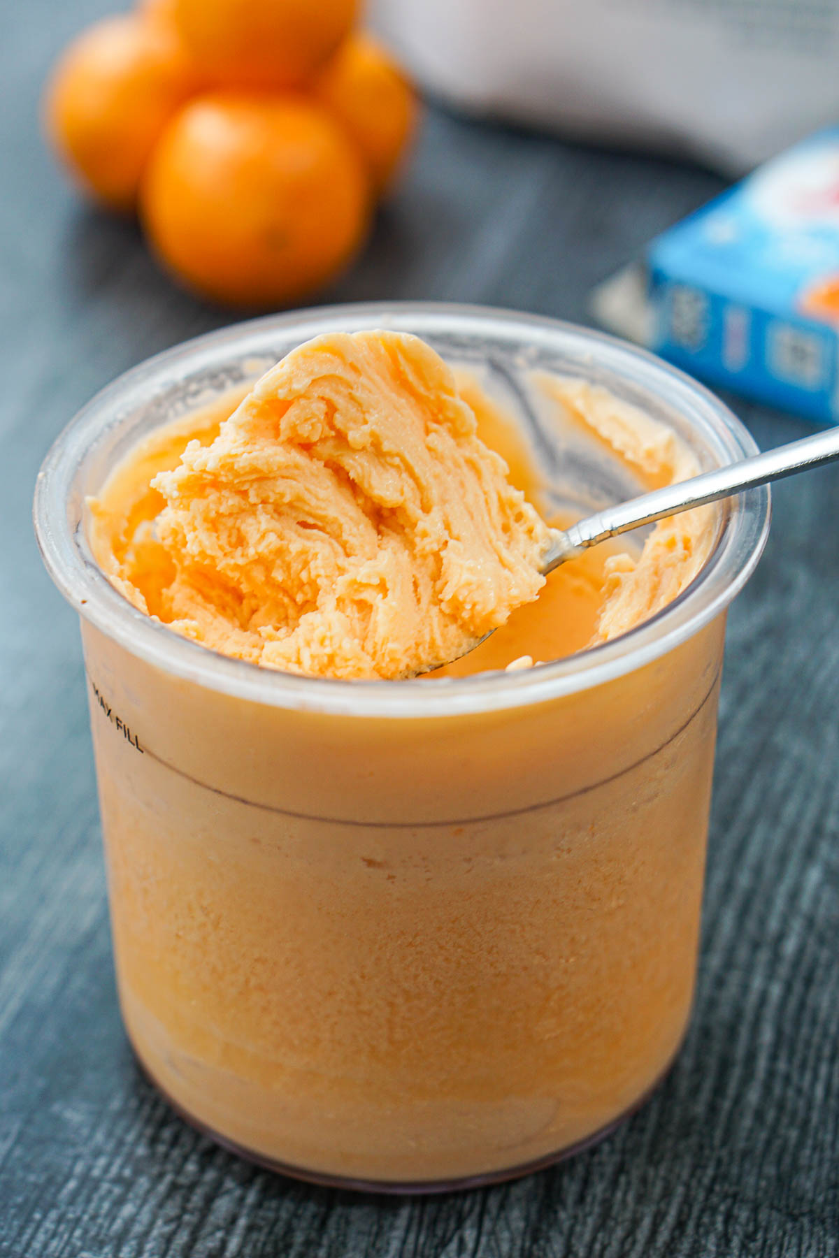 closeup of a pint container with a spoon of finished creamsicle ice cream