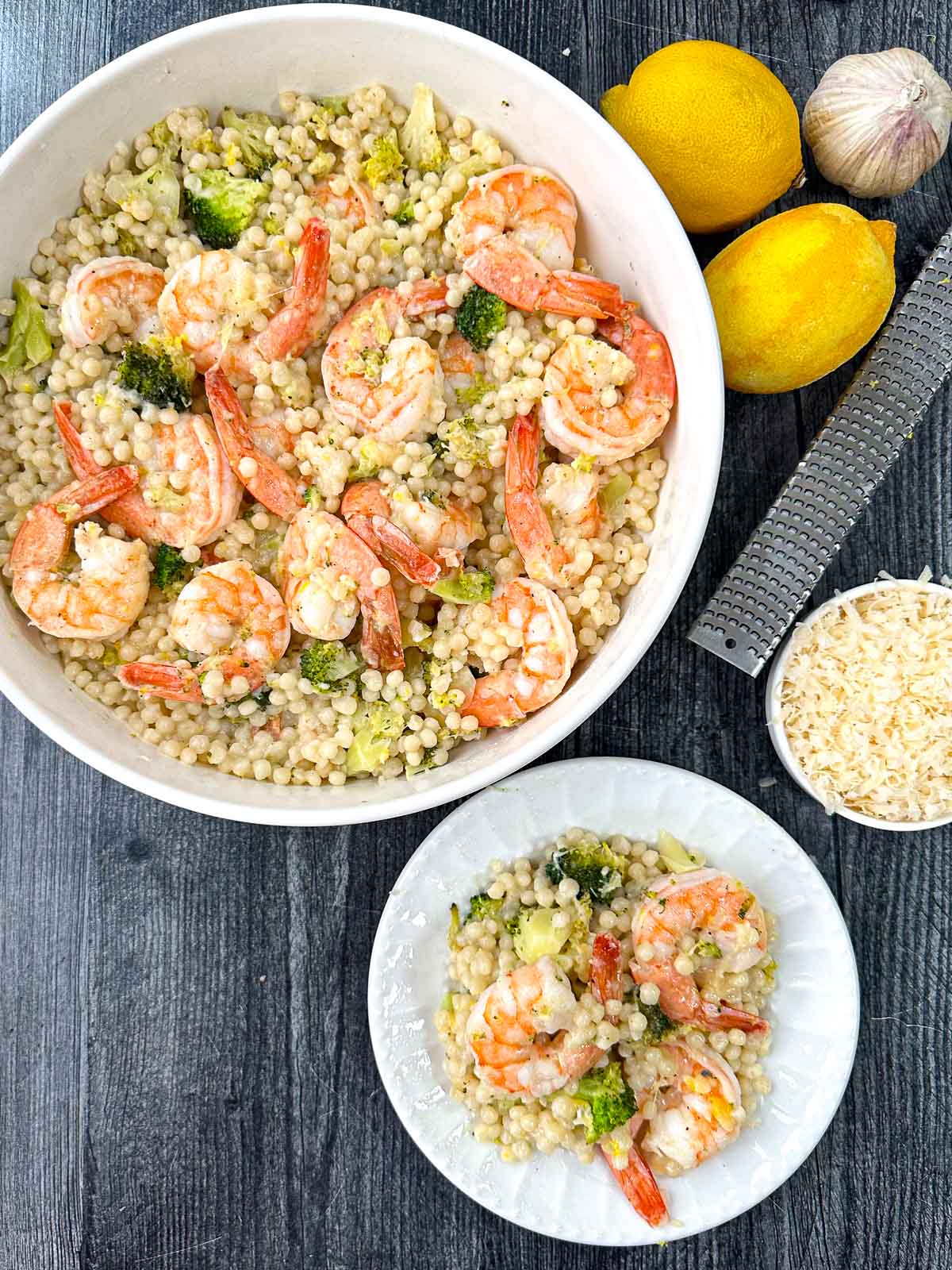 aerial view of white bowl and plate with parmesan shrimp and couscous with fresh lemon