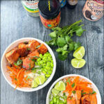 aerial view of Asian salmon buddha bowls with fresh cilantro and limes and text