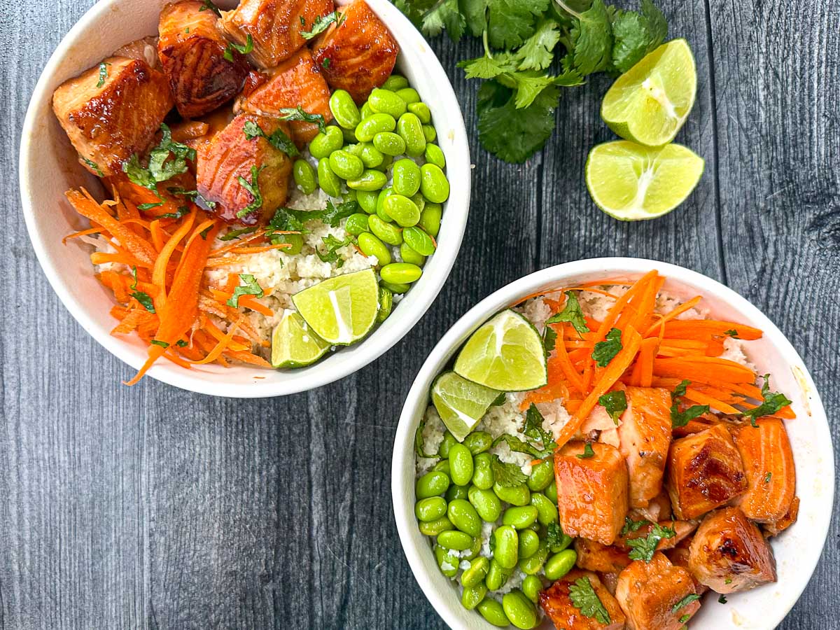 aerial view of Asian salmon buddha bowls with fresh cilantro and limes