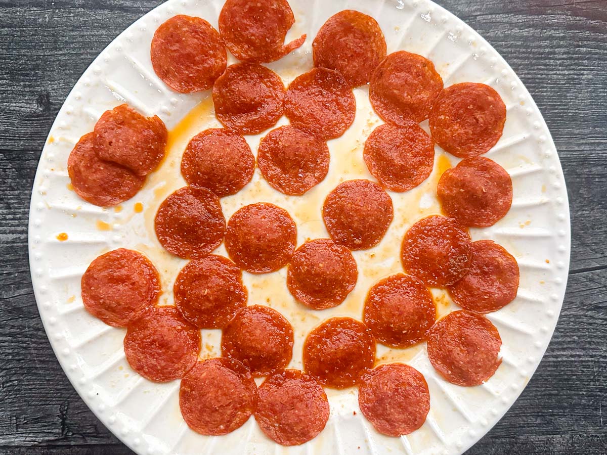 white plate with pepperoni chips out of the microwave