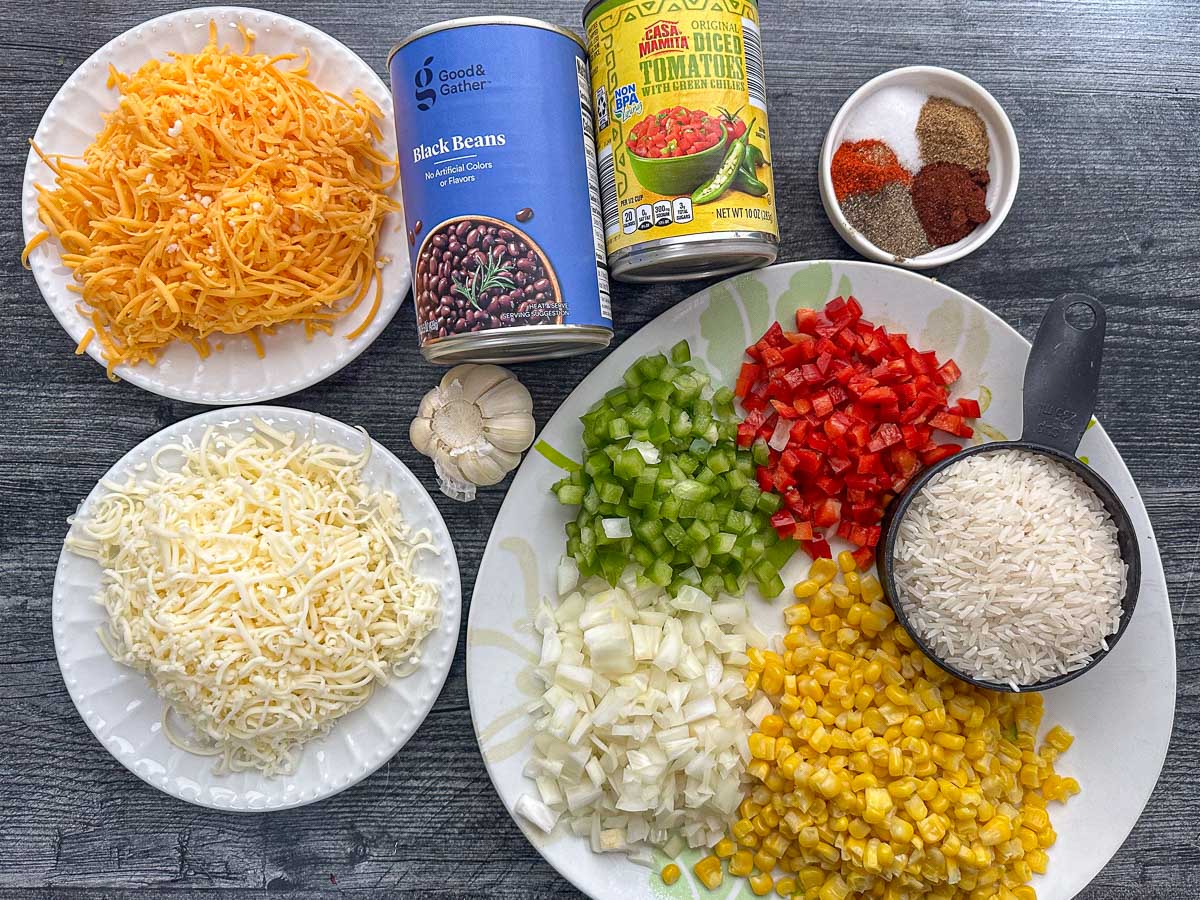 recipe ingredients - chopped veggies, rice, cheeses, beans, canned tomatoes, and spices