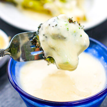 a forkful of broccoli dipped in sauce