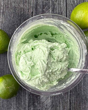 aerial view of a pint container with Ninja cream keto lime ice cream and few fresh limes