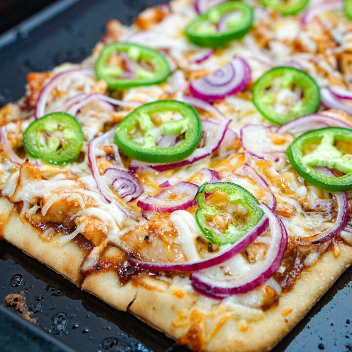 Closeup of a baking sheet with the finished bbq chicken flatbread.
