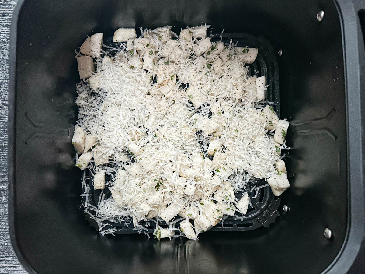 Air fryer basket with chopped turnips ready to bake.