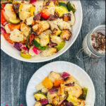 Aerial view of a white bowl and plate with the air fryer chicken bites with vegetables and text overlay.